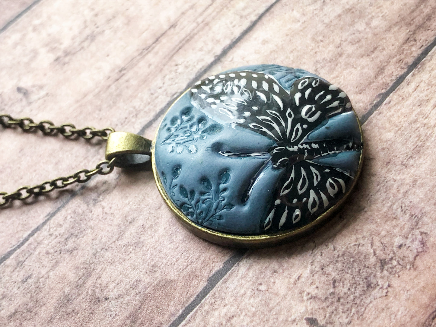 Hand Painted Black and White Butterfly on Large Blue Clay Cabochon Pendant