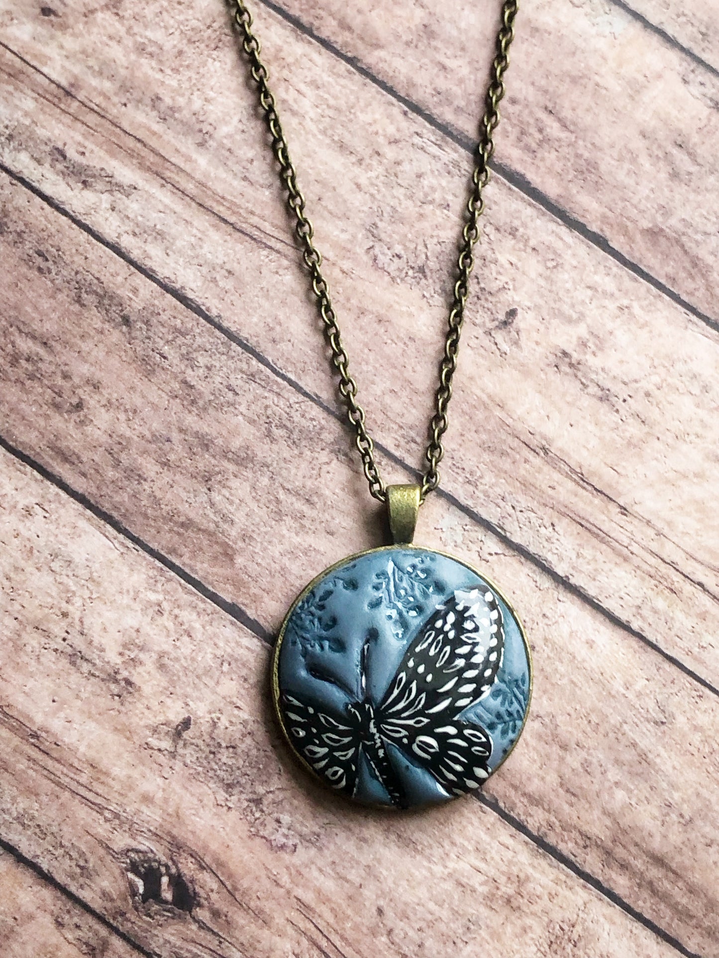 Hand Painted Black and White Butterfly on Large Blue Clay Cabochon Pendant