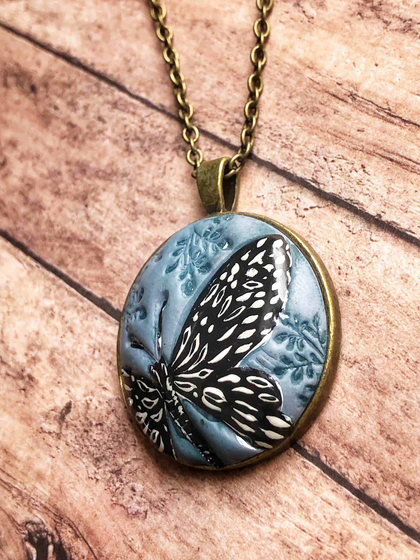 Hand Painted Black and White Butterfly on Large Blue Clay Cabochon Pendant