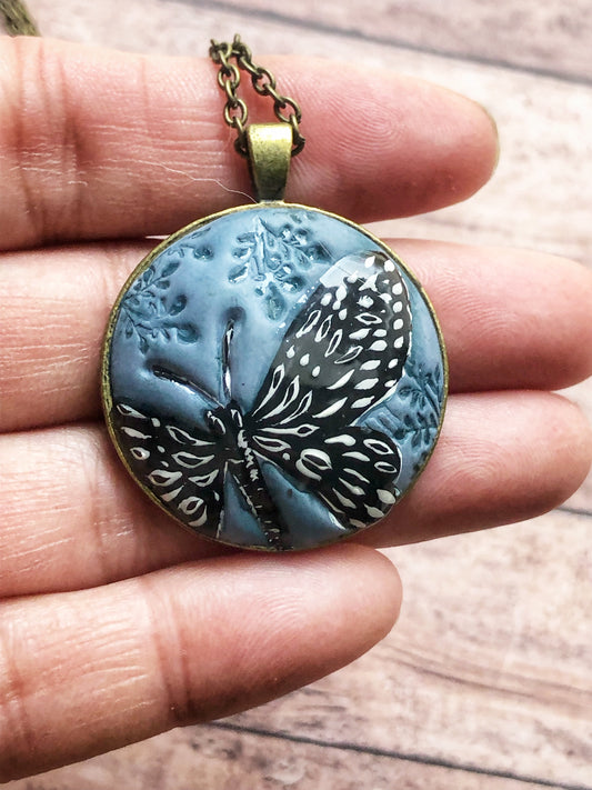 Hand Painted Black and White Butterfly on Large Blue Clay Cabochon Pendant
