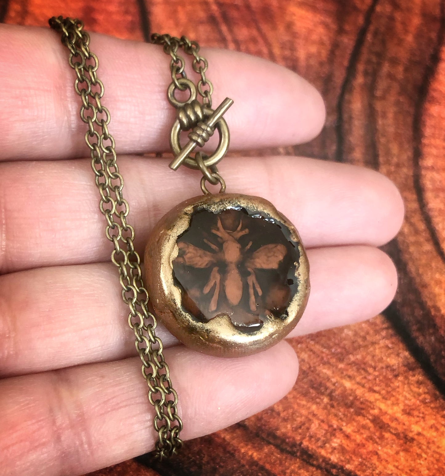 Hand Carved Clay Bee Encased in a Resin Seal Enhanced with Antique Gold