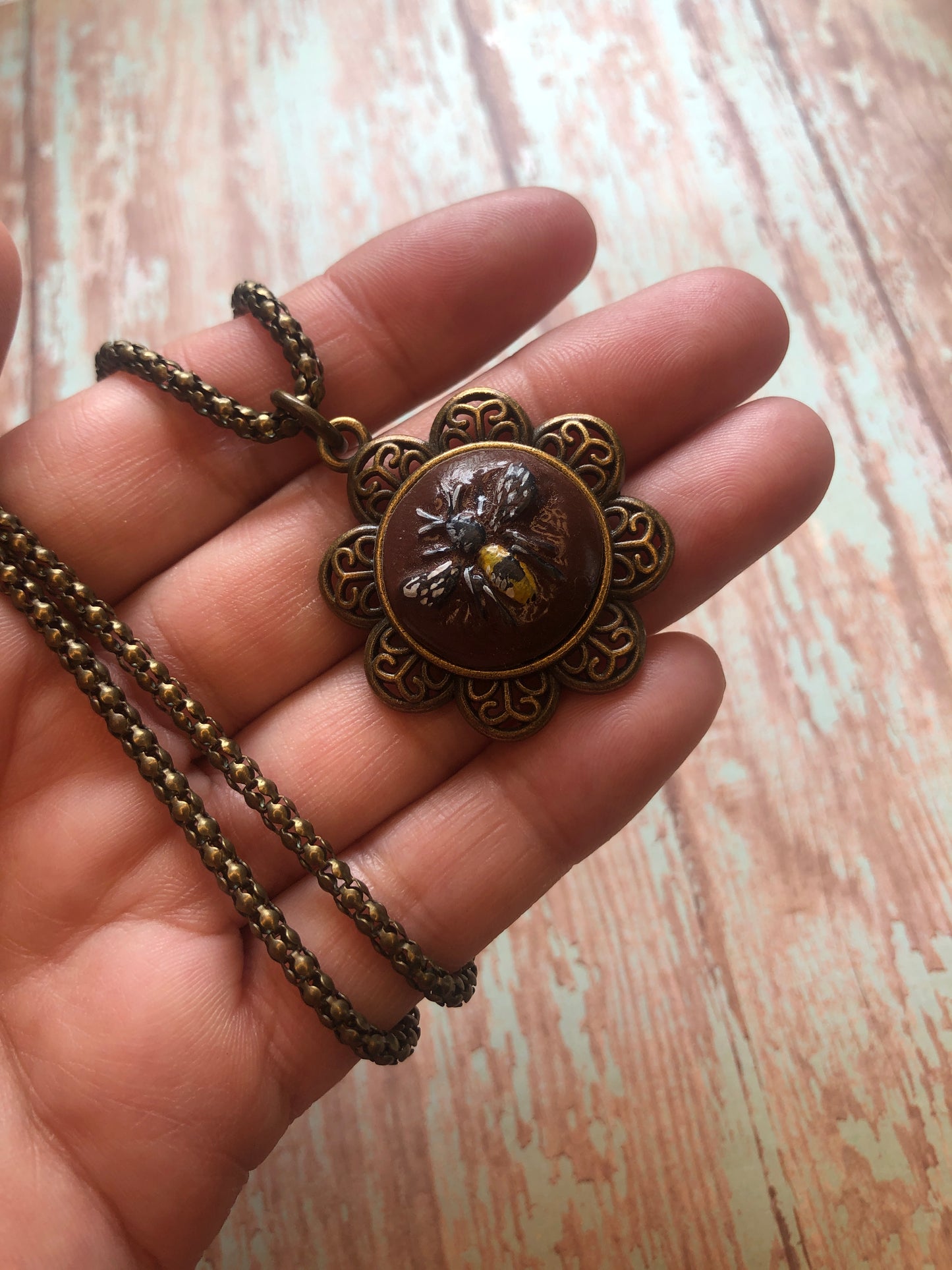 Carved Bee on Brown Clay Set in an Antiqued Brass Flower hum on an 20” Coordinating Snake Chain