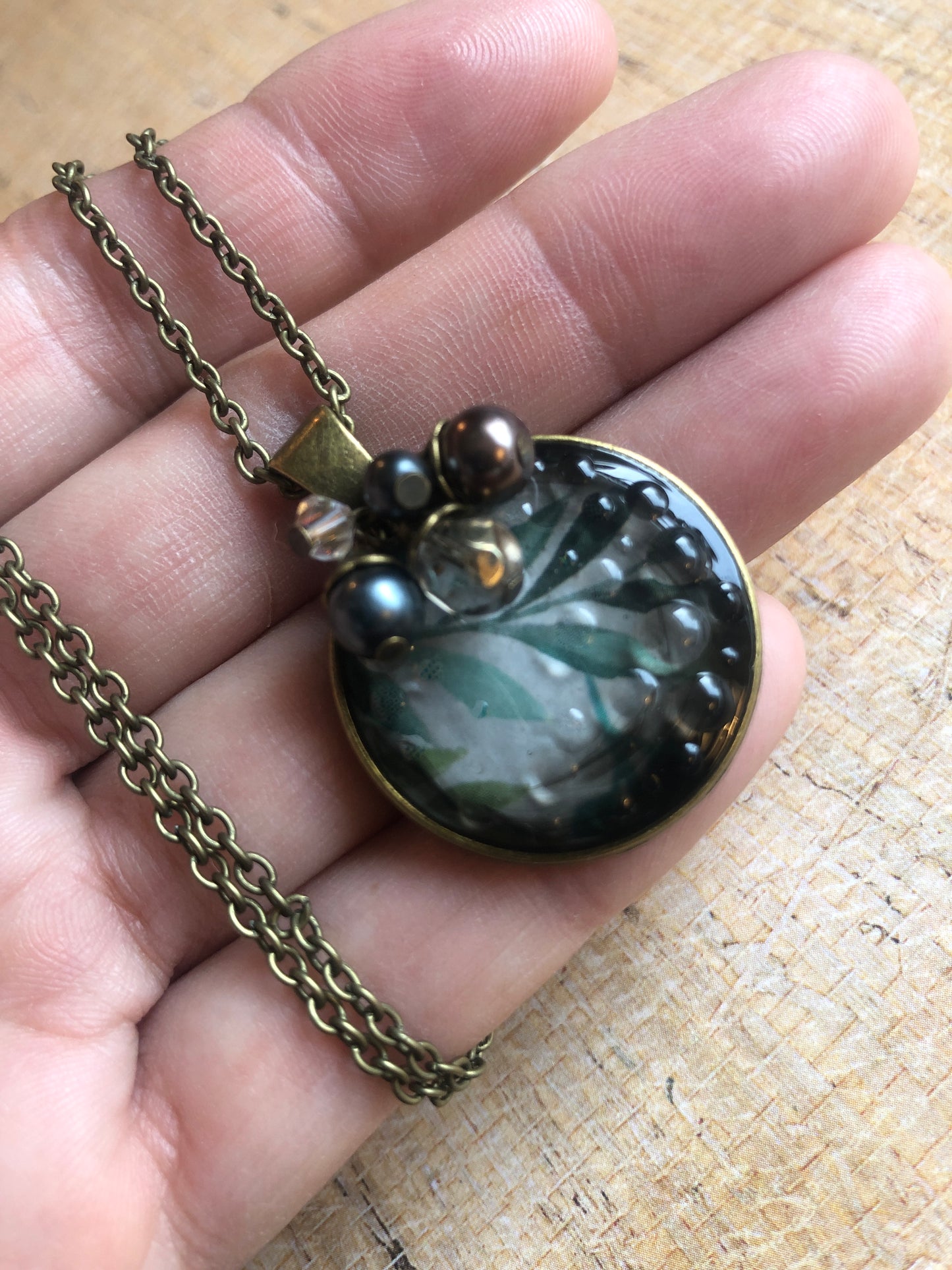 Murky water pendant with water color leaves in resin accented with sparkle and pearls on antiqued brass chain