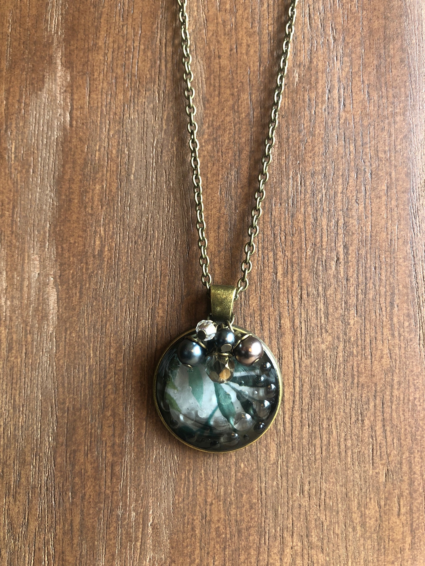 Murky water pendant with water color leaves in resin accented with sparkle and pearls on antiqued brass chain