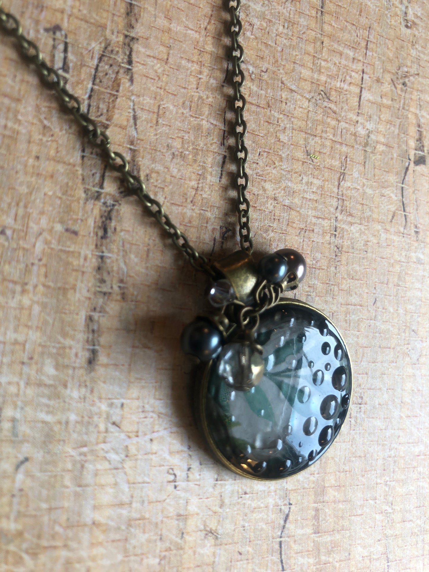 Murky water pendant with water color leaves in resin accented with sparkle and pearls on antiqued brass chain