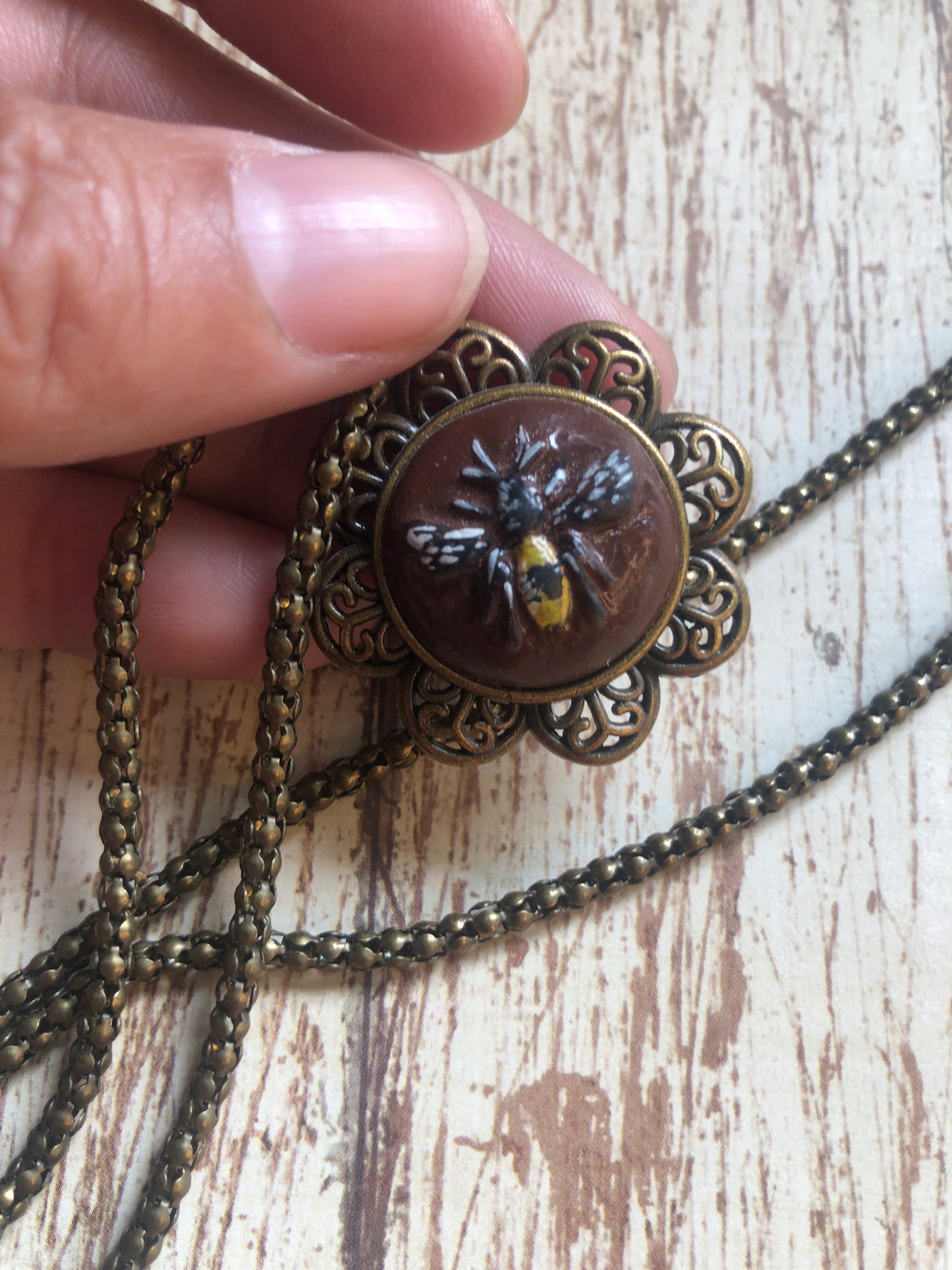 Carved Bee on Brown Clay Set in an Antiqued Brass Flower hum on an 20” Coordinating Snake Chain